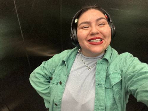 self image taken of Kasside in an elevator with headphones on