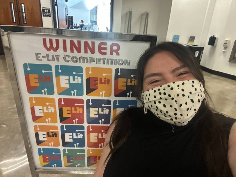 kasside in front of winner sign